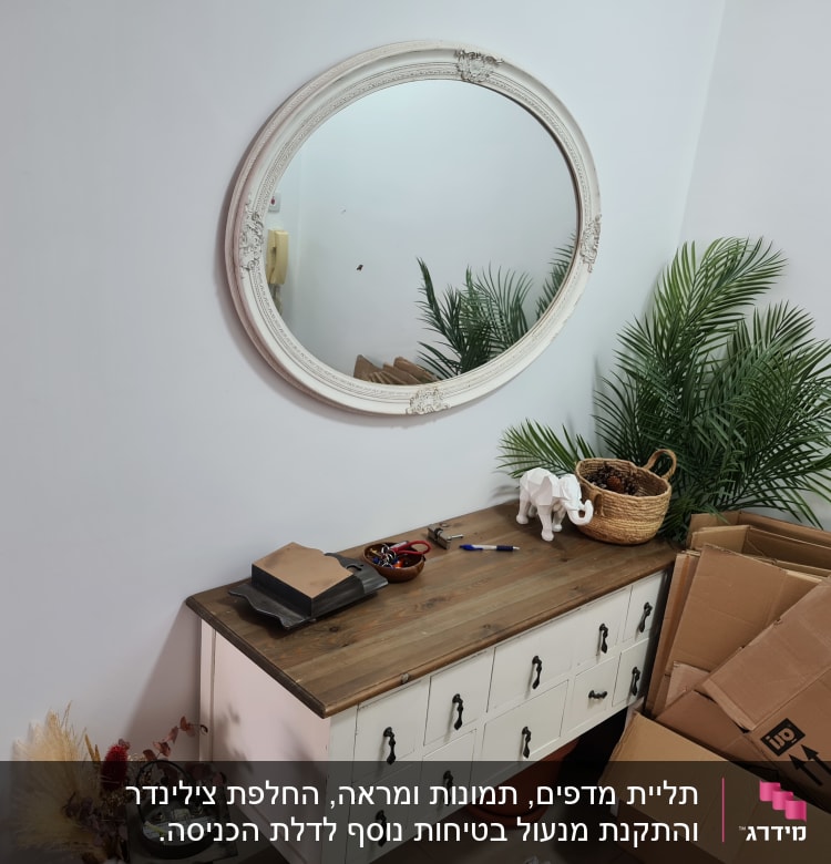 שולחן עם כלי עבודה, קופסאות קרטון ומראה עגולה